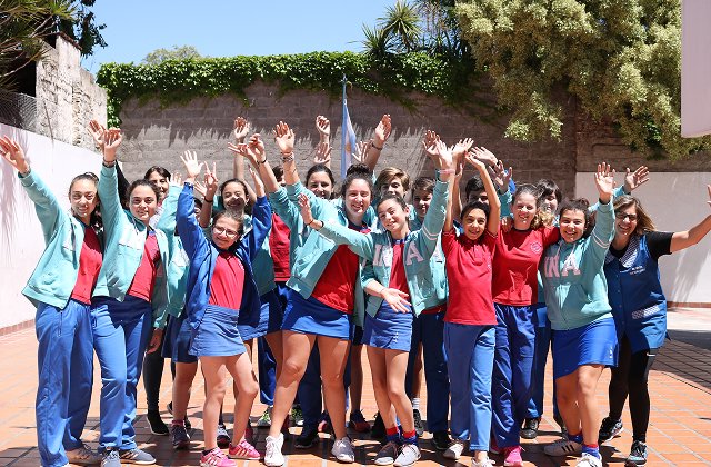 Alumnos y alumnas de primaria alzando los brazos